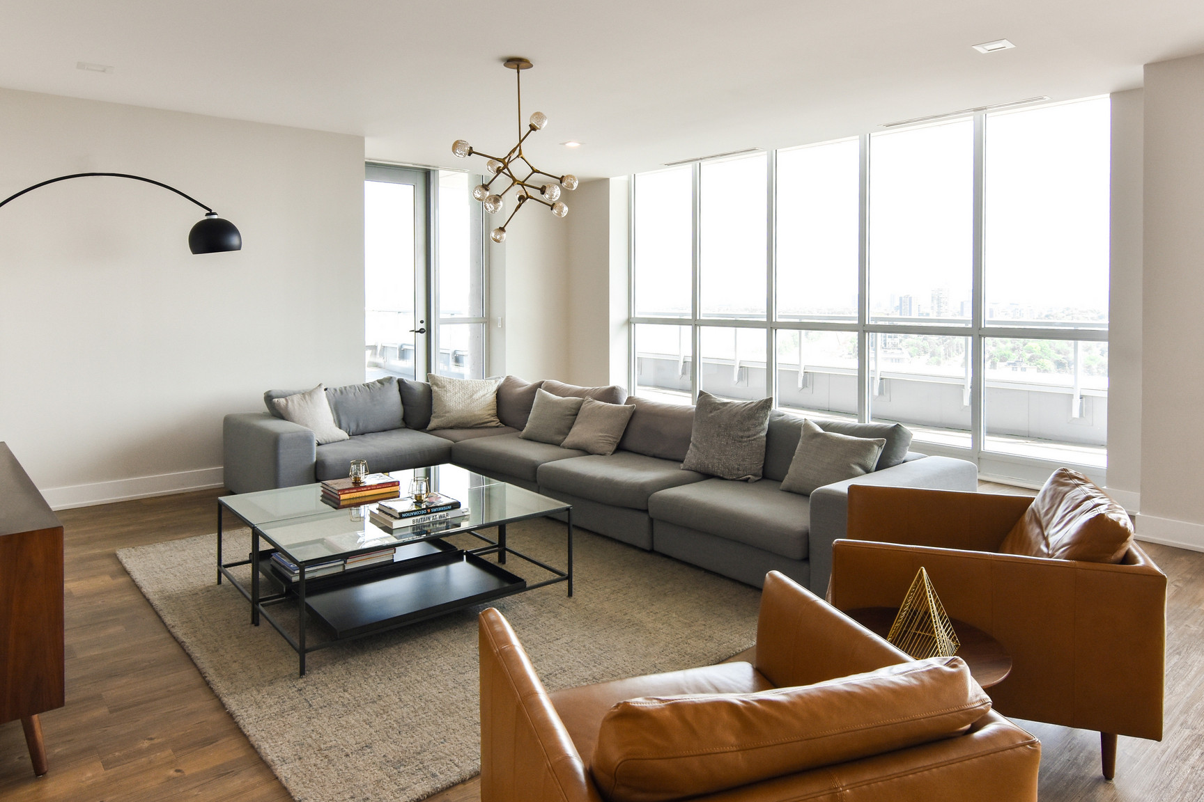 Phòng khách căn hộ hiện đại với sofa, bàn trà và cửa sổ lớn